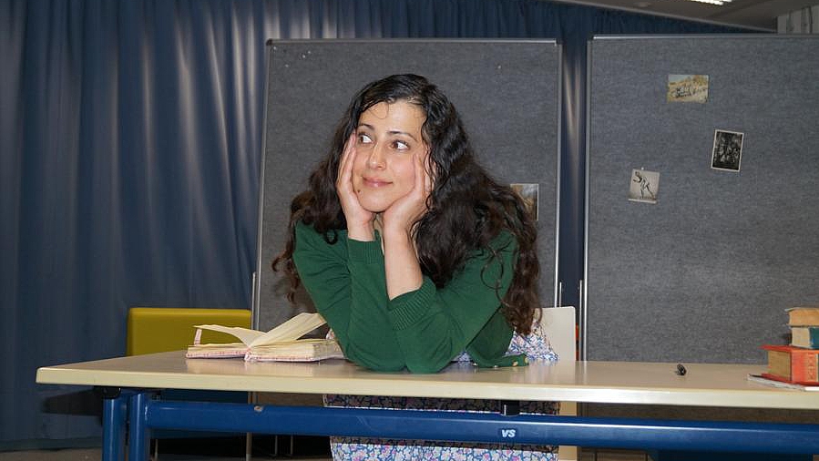 Darstellerin Sabine Soydan als Anne Frank am Schreibtisch während der Theateraufführung in der Aula der OWS.