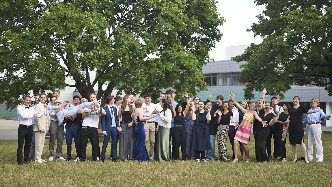 Gruppenfoto der 17 Absolventinnen und Absolventen des Technischen Gymnasiums Umwelttechnik mit Lehrkräften bei der Abiturfeier auf dem Schulgelände.