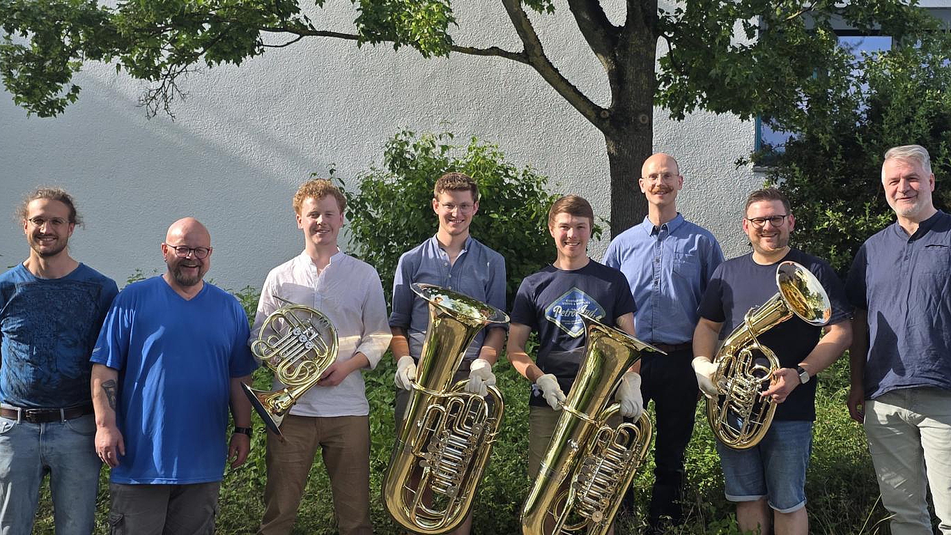 Absolventen und Lehrer des Meisterkurses im Metallblasinstrumentenbau mit ihren Prüfungsarbeiten vor der Oscar-Walcker-Schule.