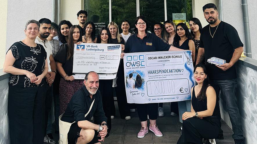 Gruppe von Auszubildenden und Beteiligten der Oscar-Walcker-Schule in Ludwigsburg mit zwei großen Spendenschecks über insgesamt 2.550 Euro für den ASB-Wünschewagen.