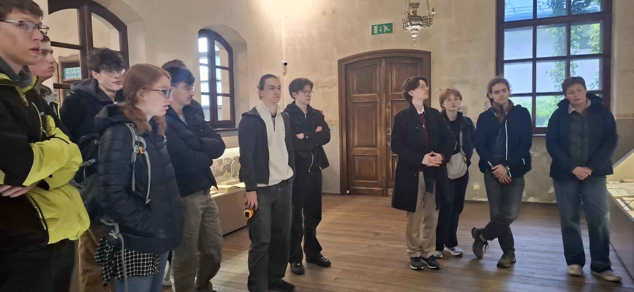 Schülergruppe mit der Schulleiterin bei einer Führung in einer Ausstellung während der Gedenkstättenfahrt.